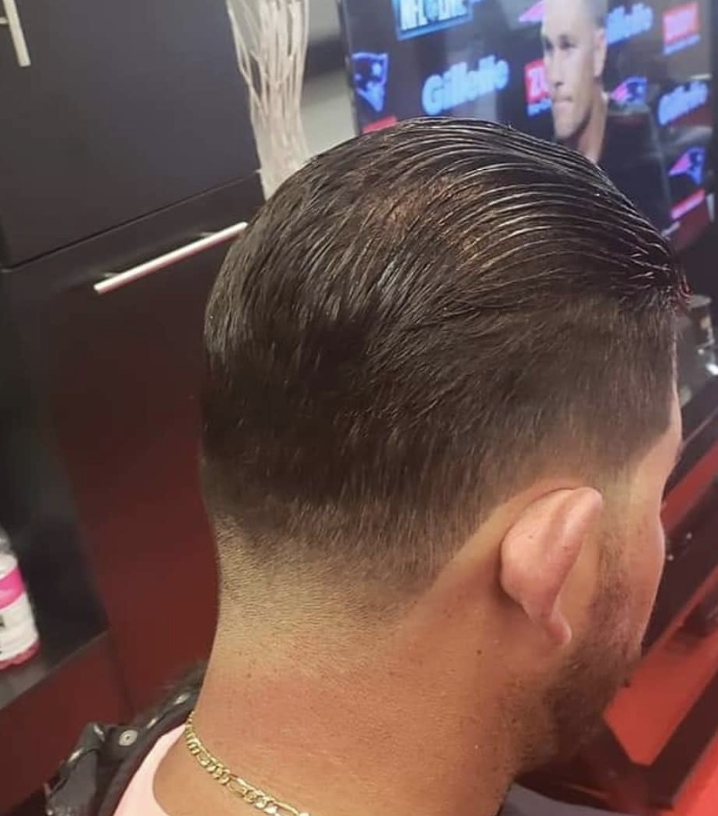 Slicked haircut with a smooth low fade at the neckline