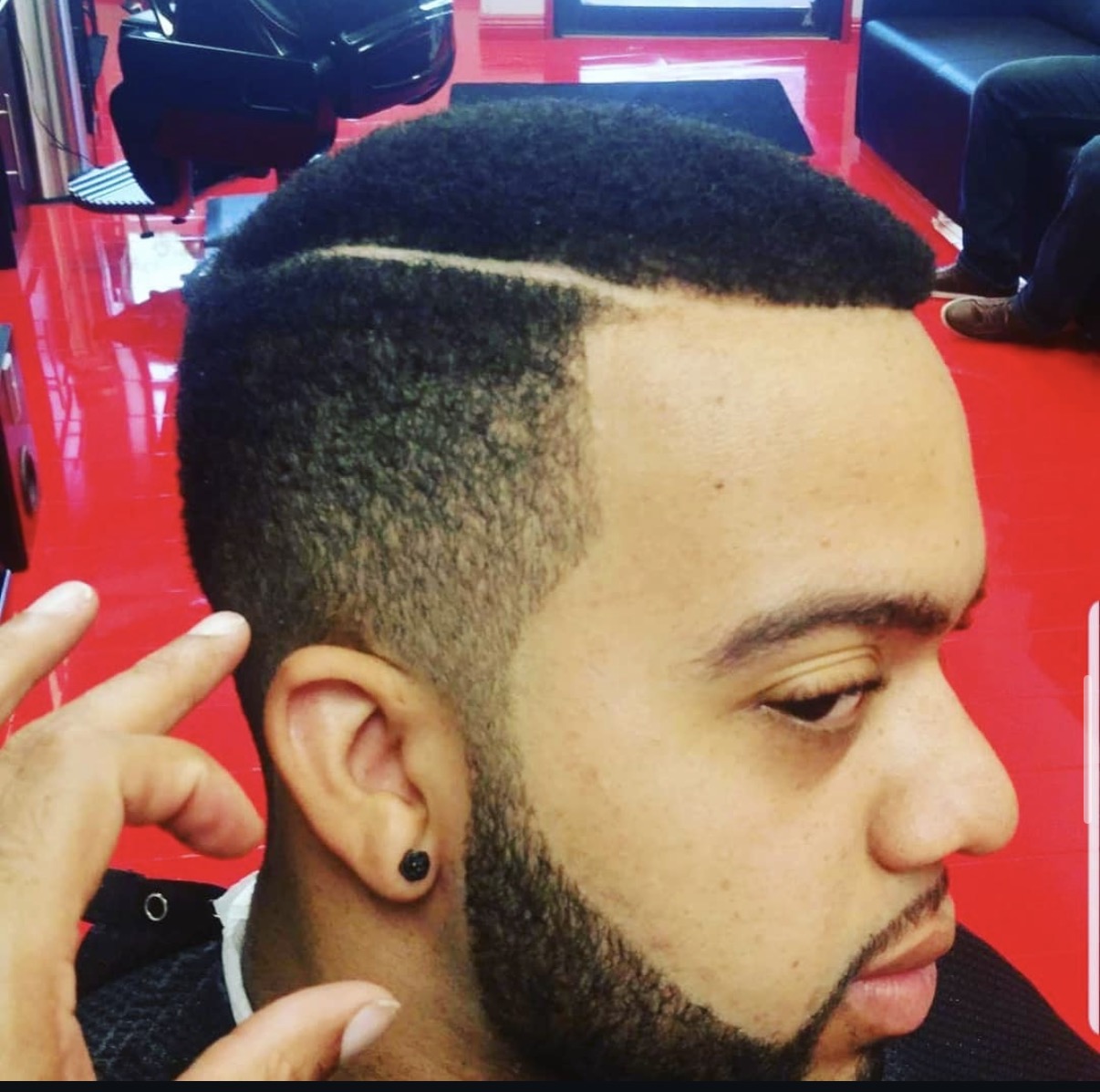Textured haircut with a razor part, fade, and shaped beard